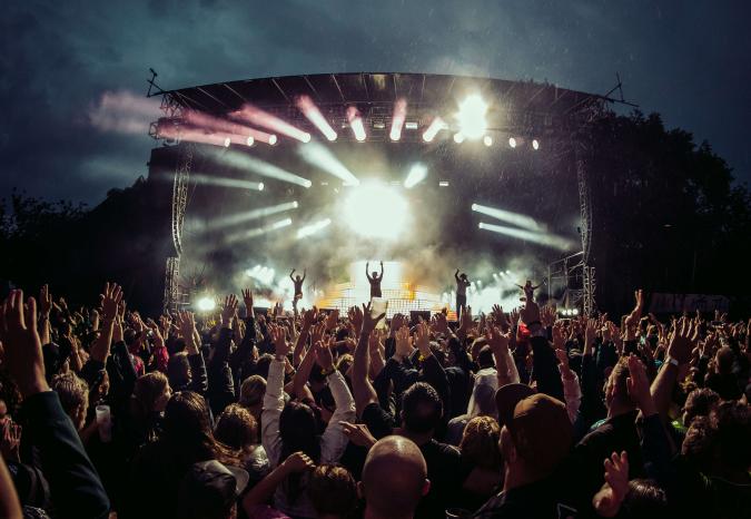 Ein großes Publikum vor einer Freiluftbühne bei Nacht.