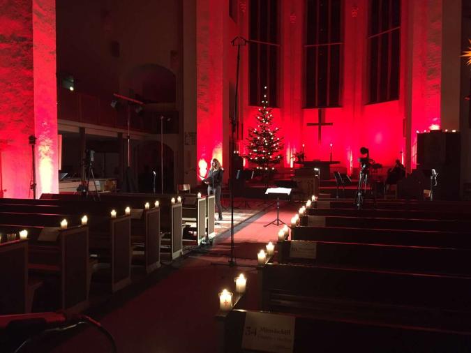 In rotes Licht getauchter Kirchenraum mit Weihnachtsbaum