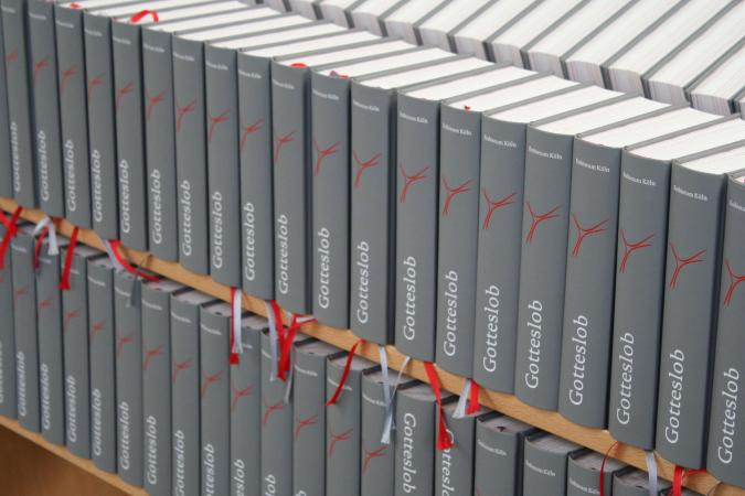 Zwei volle Regalbretter mit Ausgaben des "neuen" Gotteslobs, dem gemeinsamen Gebets- und Gesangbuch der katholischen Bistümer in Deutschland, Österreich und Südtirol.