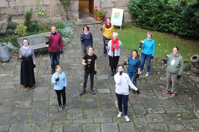 Mitglieder des Handglockenchors mit ihren Instrumenten vor der Kirche in Bad Schandau