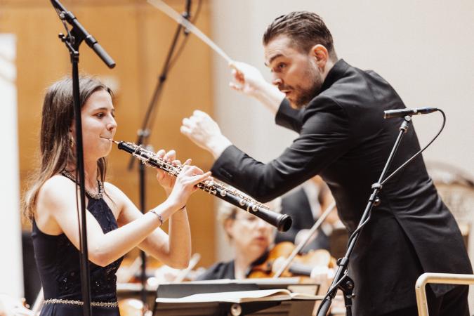 Eine Klarinettistin neben einem Dirigenten