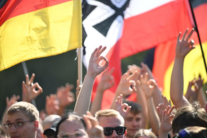 Teilnehmer einer extrem rechten Demonstration zeigen die OK-Geste, die als W(hite) P(ower) gelesen werden kann.