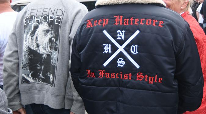 Mann in Bomberjacke mit Aufschrift Keep Hatecore in Fascist Style und dem Logo NSHC, was für National Socialist Hardcore steht