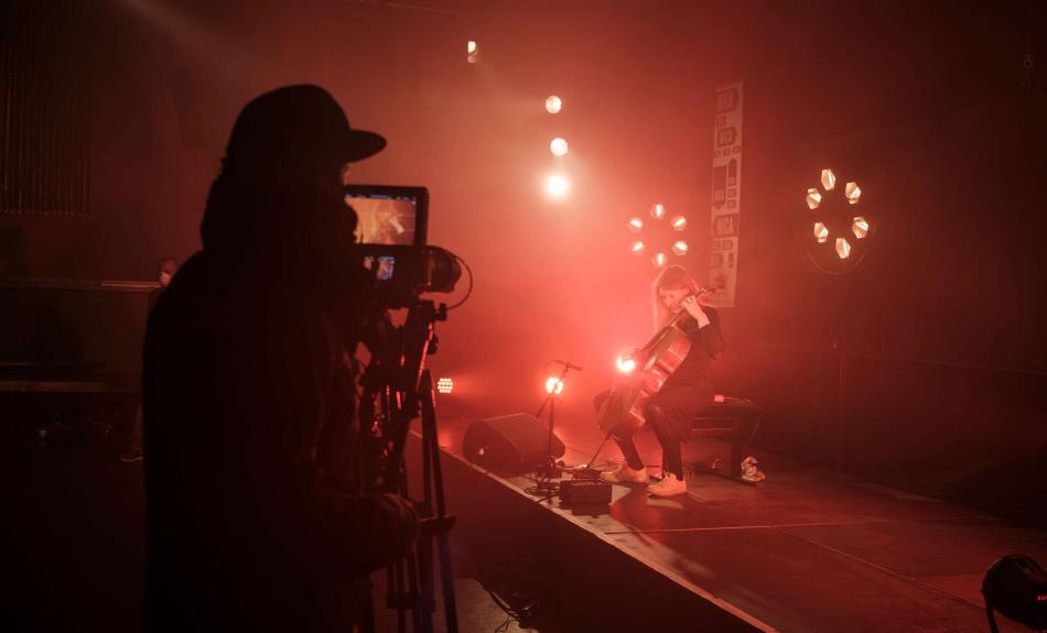 Hinter den Kulissen bei NICA: Cellistin Elisabeth Coudoux spielt auf der Bühne und wird dabei gefilmt.