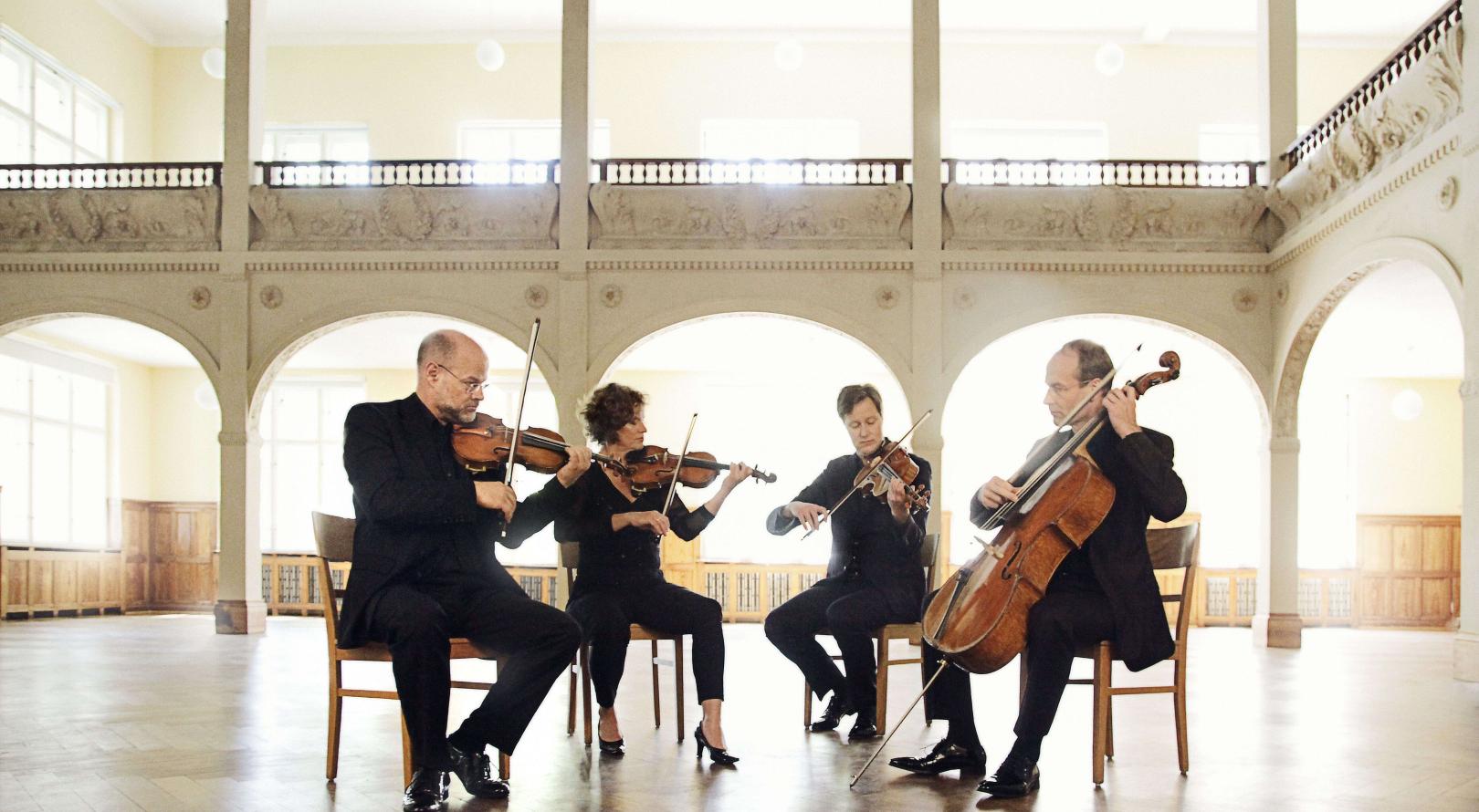 Das Mandelring Quartett spielt in einem historischen, hellbeleuchteten Saal.