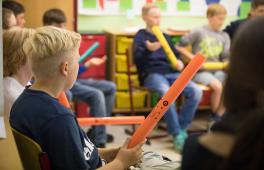 Tag der Musik an der Hochschule für Musik und Theater Rostock. Die Kinder sitzten mit Boomwhackern in einem Stuhlkreis.