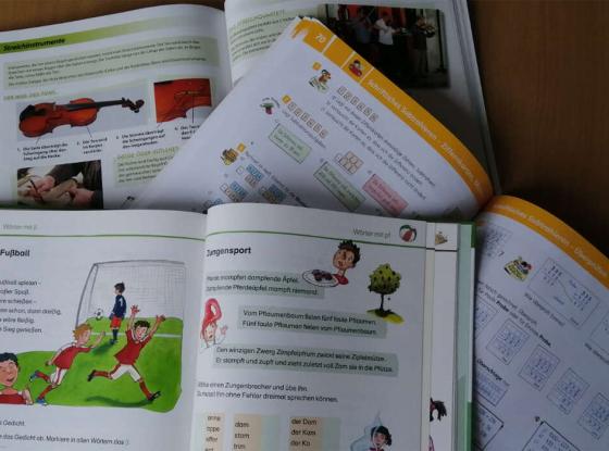Symbolbild: verschiedene aufegschlagene Schulbücher für die Grundschule.