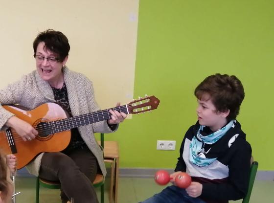 Musikunterricht an der Marienschule in Bad Hönningen. Die Rektorin singt mit den Kindern und begleitet dabei mit der Gitarre.