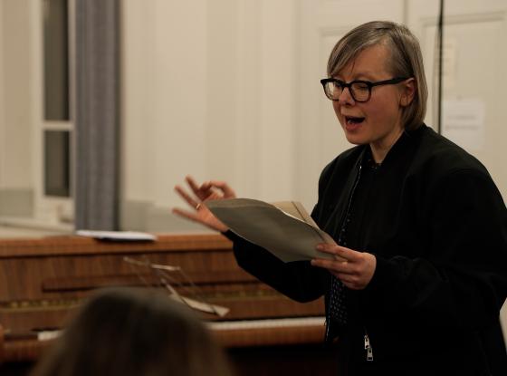 Chorleiterin erläutert eine Partitur